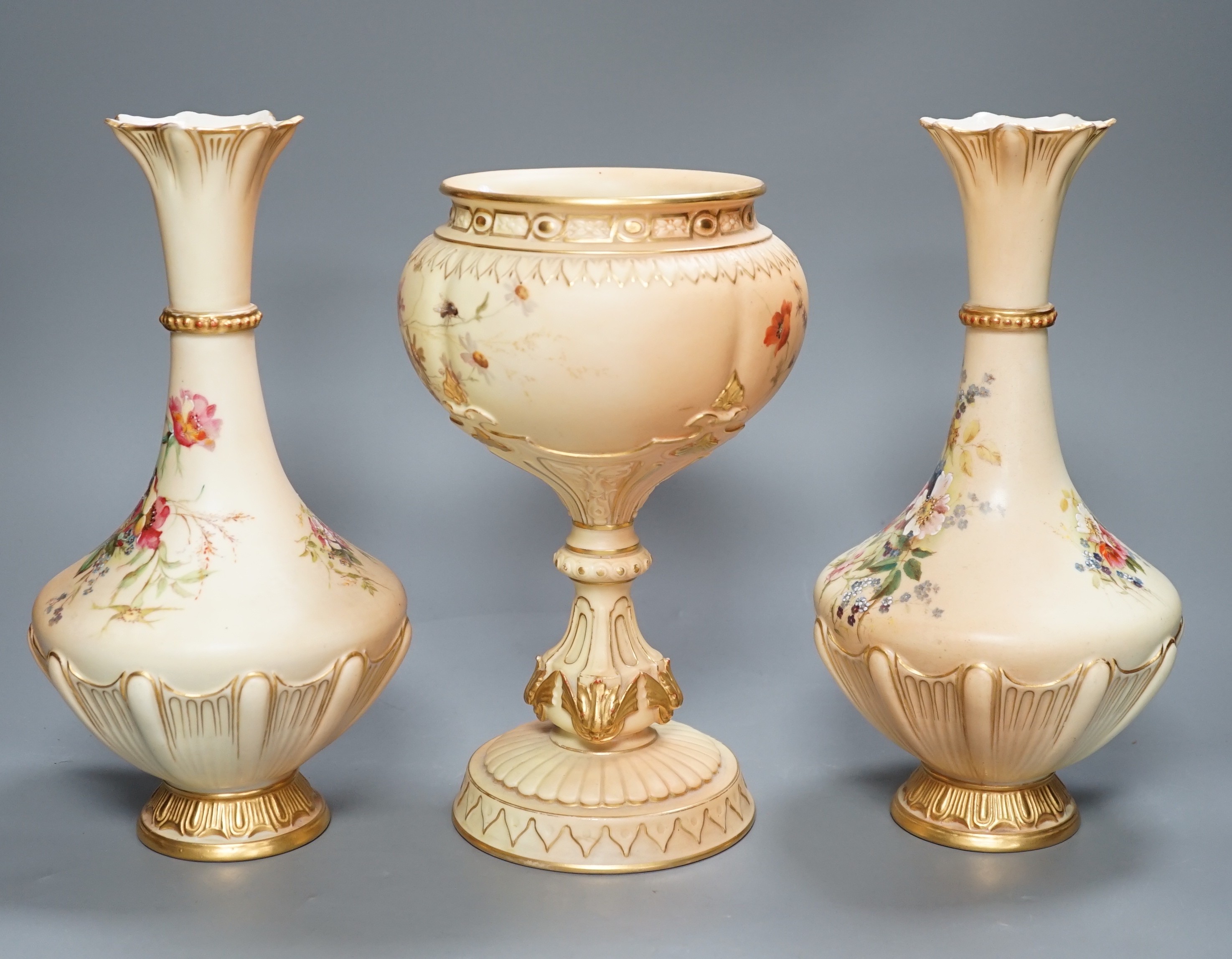 A pair of Royal Worcester blush ivory vases and a similar pedestal vase, tallest 27cm